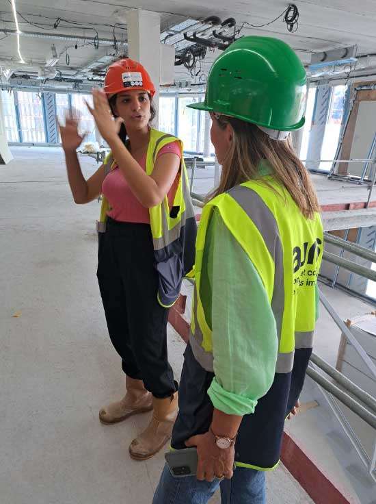 Femmes engagées sur le terrain – Auris, conseil en projets immobiliers Deux collaboratrices Auris sur un chantier en discussion, spécialisées en AMO et MOEX