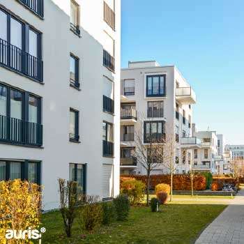 Vue sur des gratte-ciels modernes en verre, représentant le dynamisme du secteur immobilier et l’accompagnement des investisseurs par Auris en AMO et MOEx.